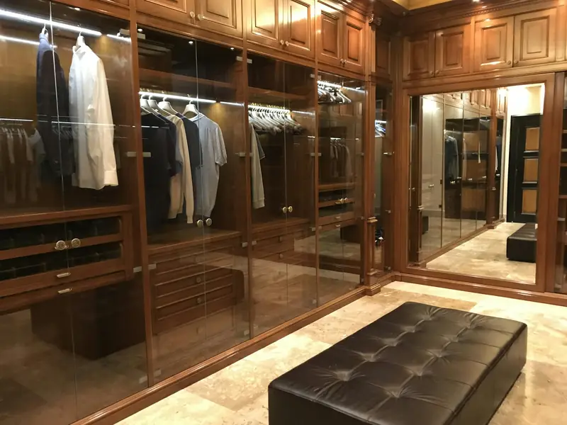 Closet de alto padrão em madeira com portas de vidro