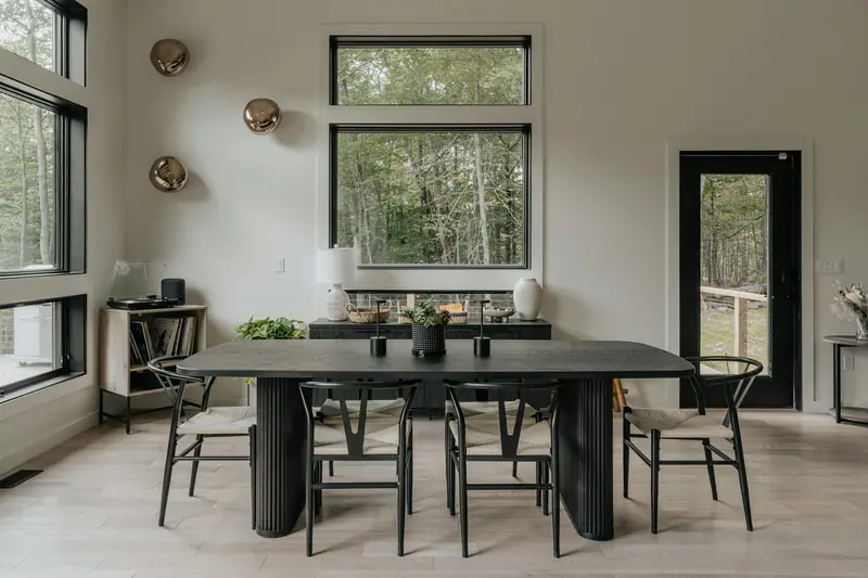 Sala de jantar com mesa escura e cadeiras de madeira